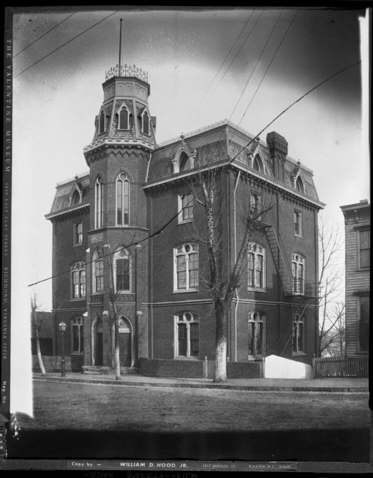 Black and white image of a 3-story school building with a round, tower-like structure centered at the front